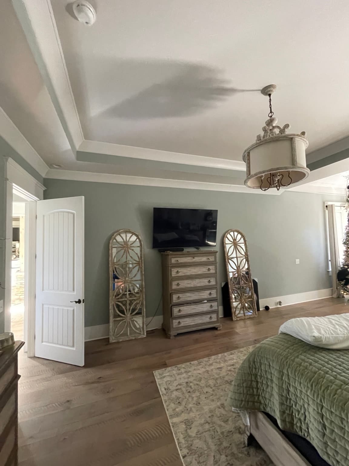 Wall-mounted TV above a dresser in a bedroom